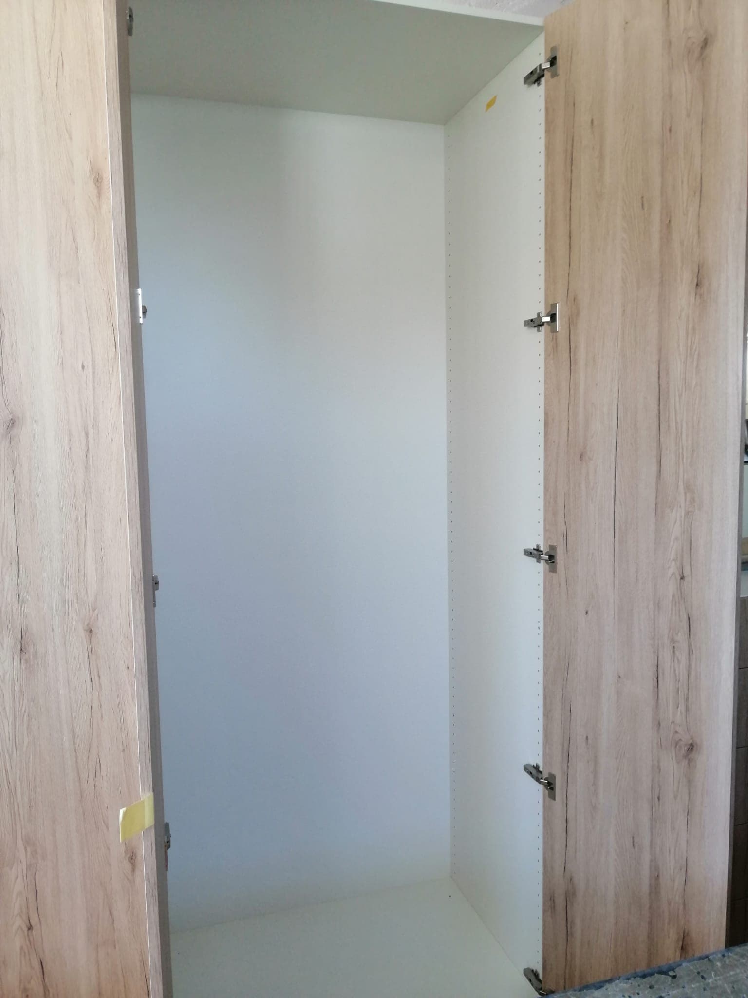Fitted wardrobe with an open door, interior view