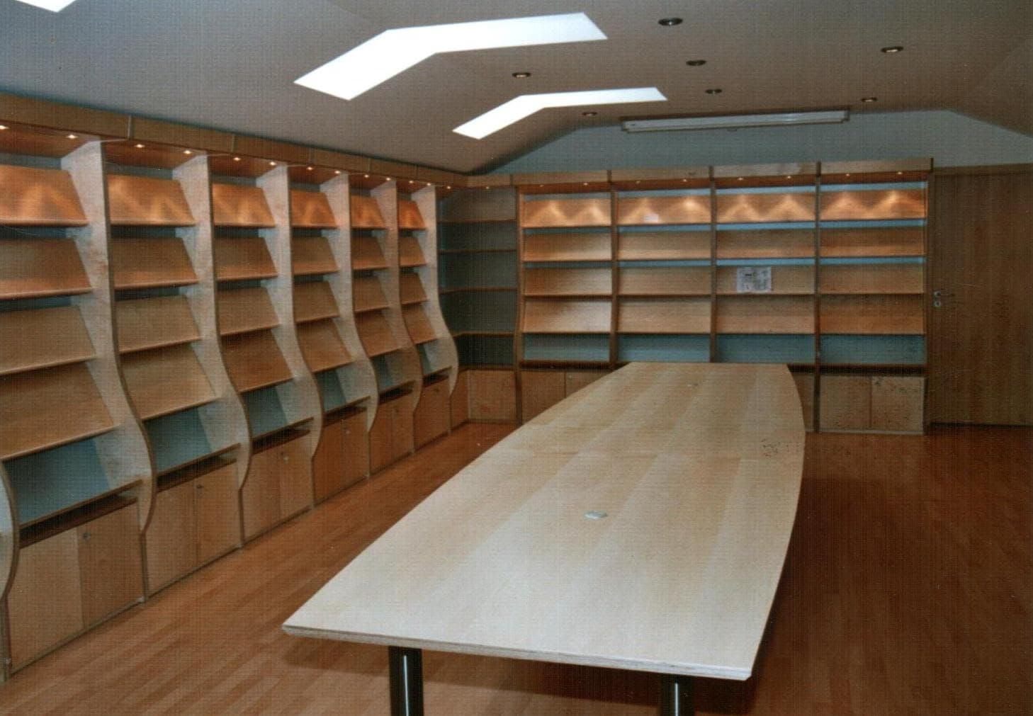 Raumlanges Einbauregal aus Holz mit geschwungenen Seiten und LED